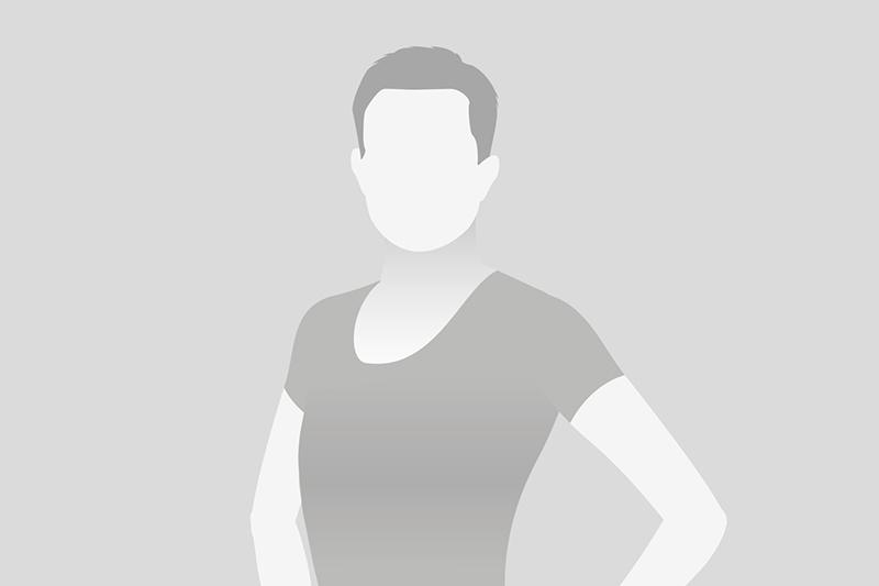 Silhouette einer Person mit kurzem Haar, in einem schlichten T-Shirt, freundlich stehend vor einem grauen Hintergrund.